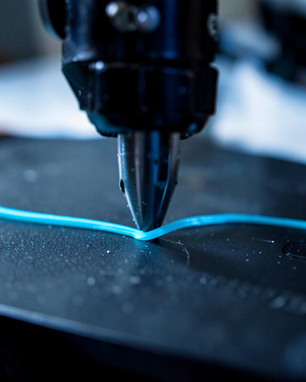 Dysza drukarki 3D układająca warstwę filamentu na stole roboczym